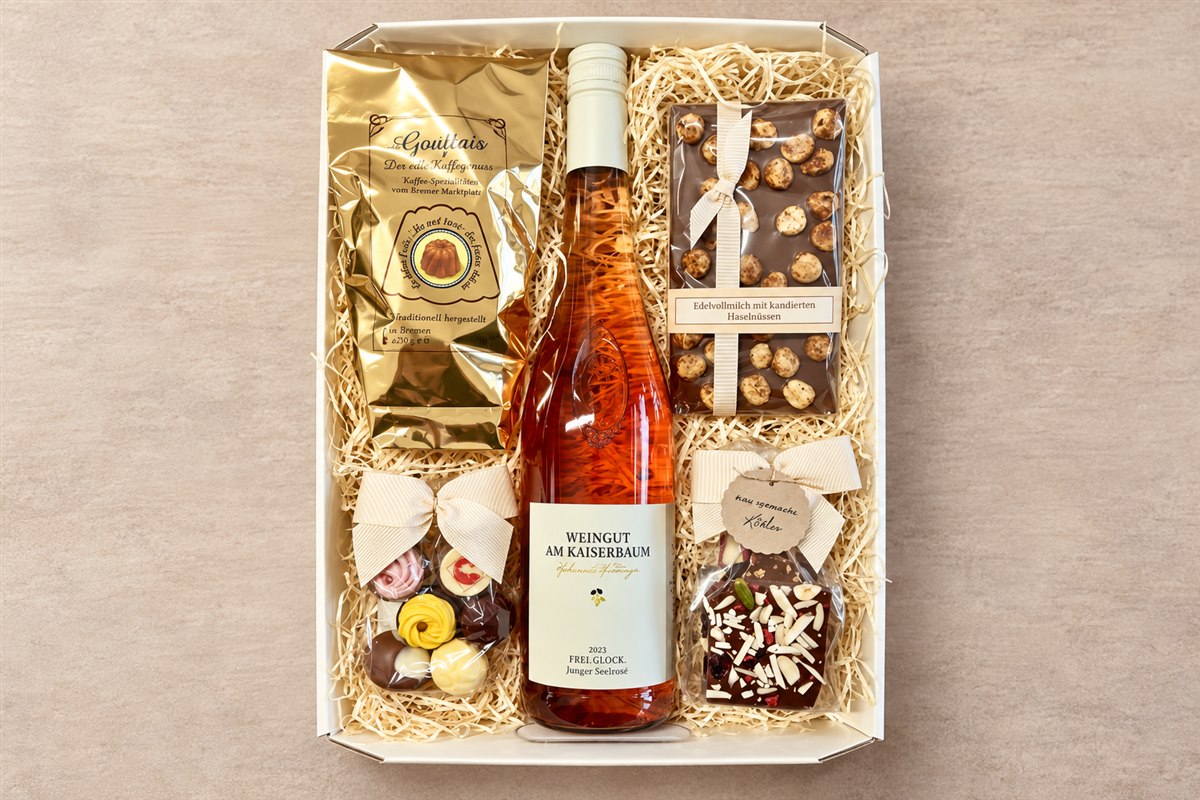 Geschenkbox mit einer Flasche, Kaffee und süßen Spezialitäten